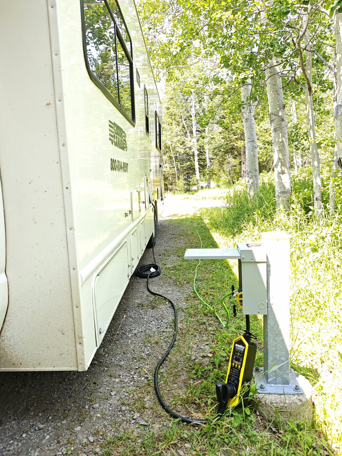 RV connected through RVShield at a shaded campground hookup